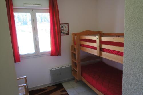 a bedroom with two bunk beds and a window at Apartment Location Les balcons de La Mauselaine in Gérardmer