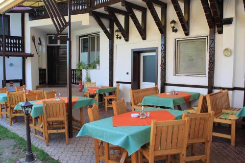 a restaurant with tables and chairs with green and red napkins at Pension Tip-Top in Târgu-Mureş