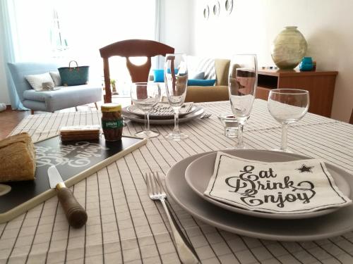 einen Tisch mit einem Teller und Weingläsern darauf in der Unterkunft Sweet Home of Cabanas in Conceição