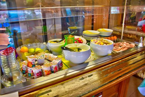a buffet with bowls and plates of food on a counter at Logis Hôtel Restaurant Le Chalet du Mont Roland in Dole