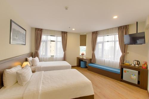 a hotel room with two beds and a flat screen tv at Central Hotel & Spa Danang in Da Nang