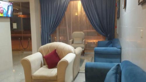a living room with two chairs and blue chairs at Luluat Najd Hotel Apartments in Buraydah