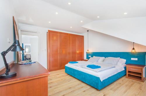 a bedroom with a bed and a desk with a lamp at Apartments Marivo in Mlini