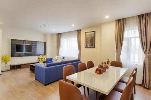 a living room with a blue couch and a table at Central Hotel & Spa Danang in Da Nang