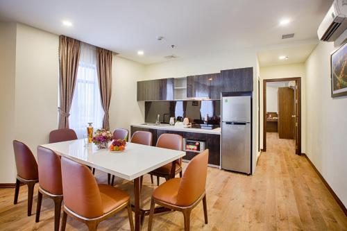 a kitchen and dining room with a table and chairs at Central Hotel & Spa Danang in Da Nang