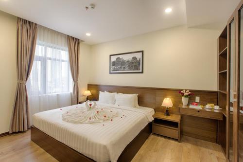 a hotel room with a bed and a window at Central Hotel & Spa Danang in Da Nang