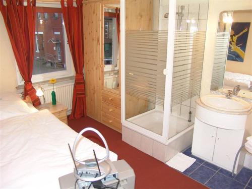 a bedroom with a bed and a shower and a sink at Deutsches Haus in Hannover