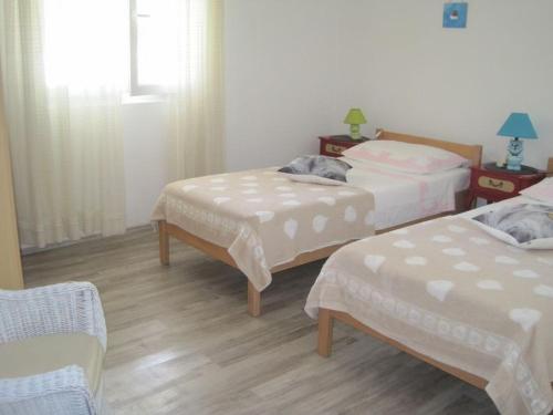1 dormitorio con 2 camas, mesa y sillas en Apartment Gale, en Maslinica