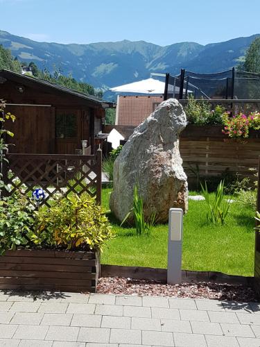 a rock sitting in the grass next to a garden at Appartement Schmittenblick in Zell am See