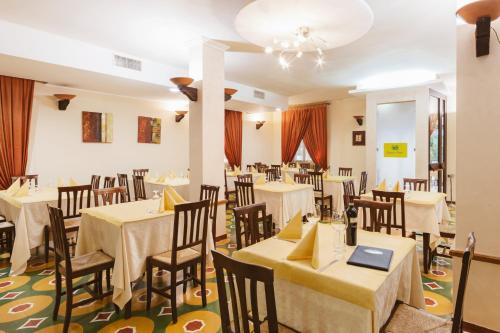 a dining room with white tables and chairs at Hotel Villa Del Sorriso in Venosa