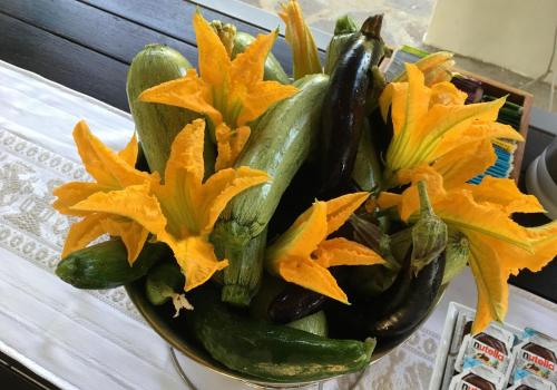 a bowl filled with cucumbers and flowers on a table at Agriturismo Parco Fiorito in Cortona