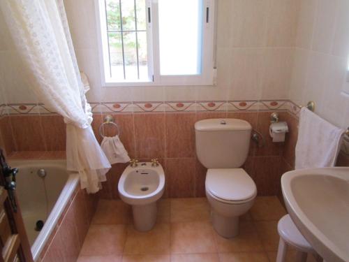 y baño con aseo, bañera y lavamanos. en Casa Rural Las Duronas, en Almagro