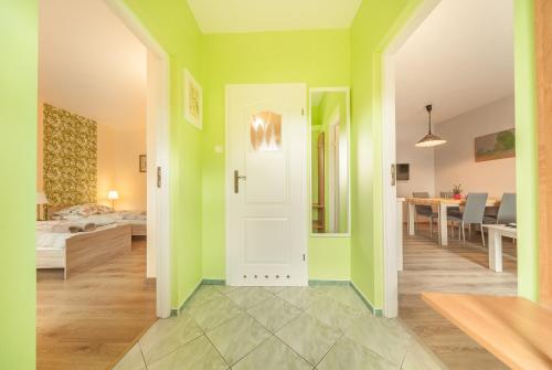 a living room with green walls and a white door at Domek w ogrodzie in Chełmno