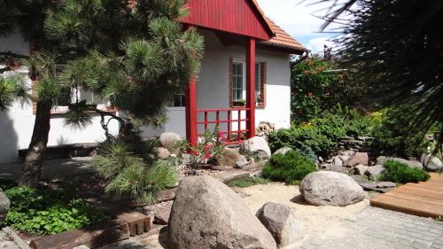 a small house with a red roof and a garden at Domek w ogrodzie in Chełmno
