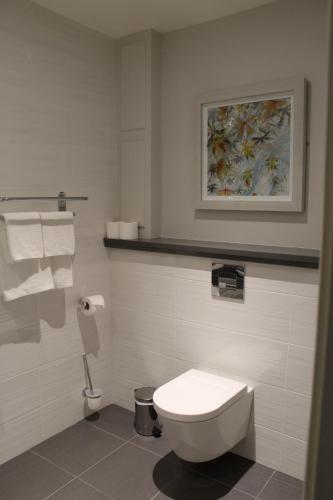 a bathroom with a toilet and a painting on the wall at Grand Hotel Tralee in Tralee