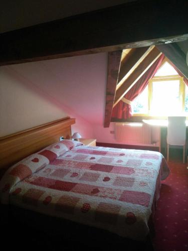 a bedroom with a bed with a red and white quilt at Rauzi Hotel Garnì & apartments in Malè