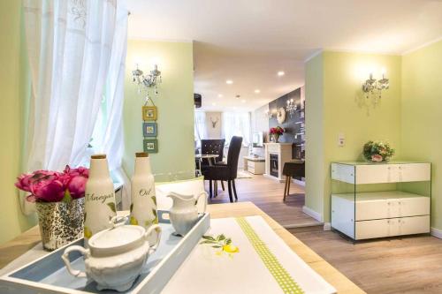 a kitchen and living room with a table with flowers at Luxuslodge Wernigerode in Wernigerode