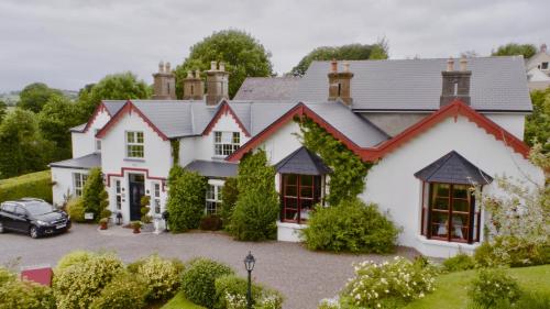 a house with a car parked in the driveway at Killeen House Hotel in Killarney