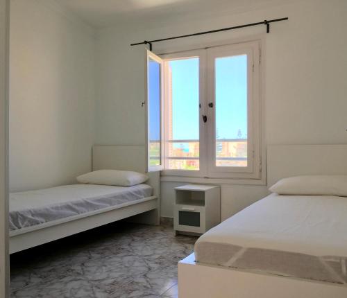 a white room with two beds and a window at Virginia Beach Standalone Villa in El Alamein