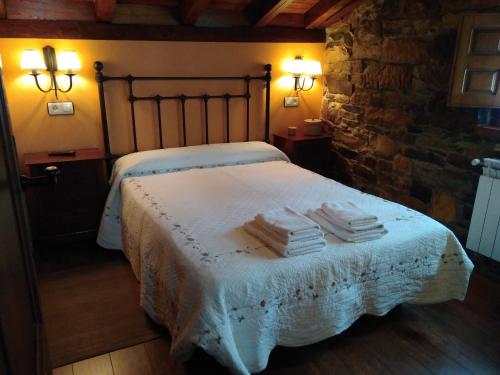 a bedroom with a bed with towels on it at Apartamentos Rurales Casa Cachon in Santa Eulalia de Cueras