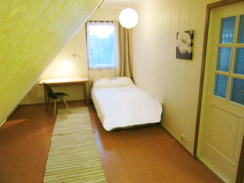 a bedroom with a bed and a desk and a window at Villa Lille in Pärnu