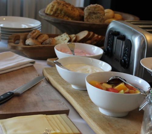 Una mesa cubierta con cuencos de comida y pan. en Hotel restaurant Nederheide, en Milheeze