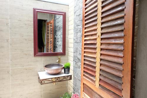 a bathroom with a sink and a mirror on a wall at Green Village Mekong in Can Tho
