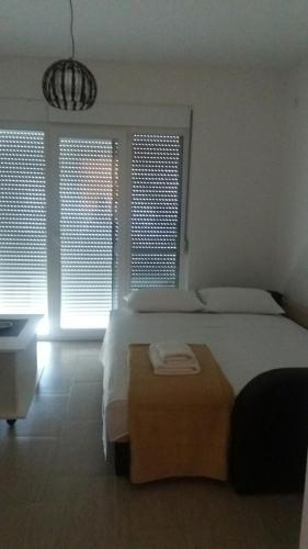 a bedroom with a bed and a table and windows at Apartment Vila Mirela in Krimovice