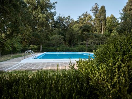 a swimming pool in the middle of a garden at Le dimore de Il borgo del balsamico in Albinea