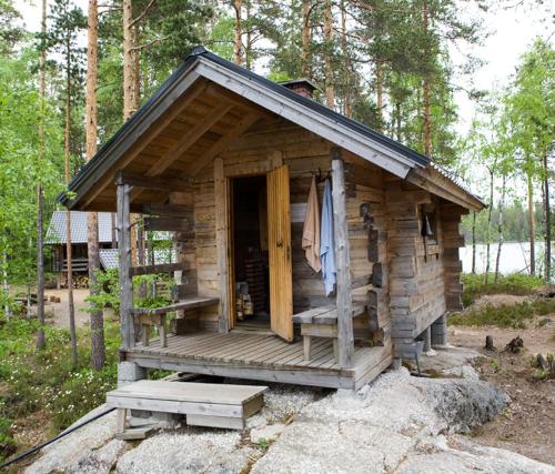 a log cabin with a porch and a door at Pielppa Lodge in Orivesi