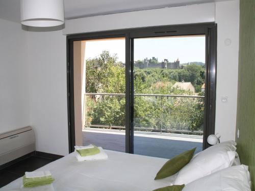 1 dormitorio con cama blanca y ventana grande en Appartement Le Saint Nazaire - Les Balcons de la Cité, en Carcassonne