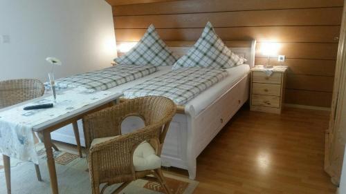 a bedroom with two beds and a table and a desk at Hotel-Pension Haus Hubertus in Weigendorf