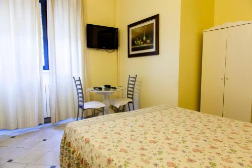 a bedroom with a bed and a table with chairs at Affittacamere Europa Fiera in Rho