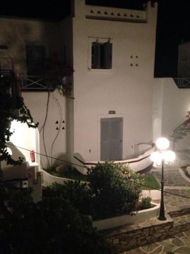 a white building with a light in front of it at Teoria Paros - Matsas Windmill in Naousa