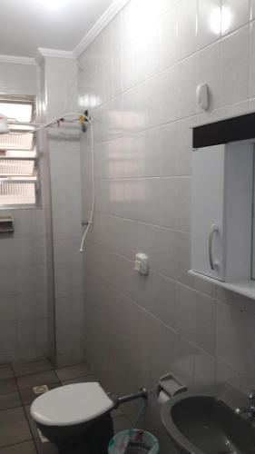 a bathroom with a toilet and a sink at Apartamento no Varandas de Itaguá in Ubatuba