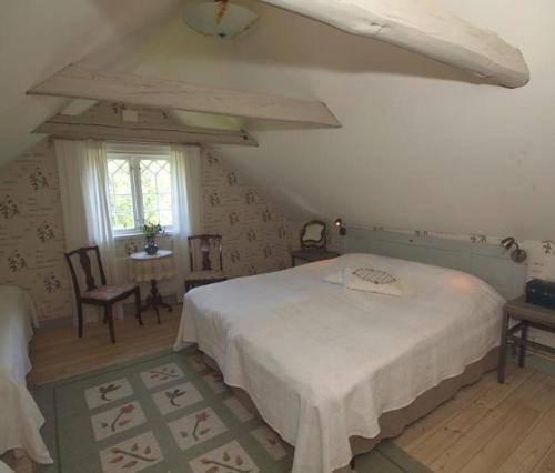 a bedroom with a bed and a table and a window at Björka Storgård B&B in Motala