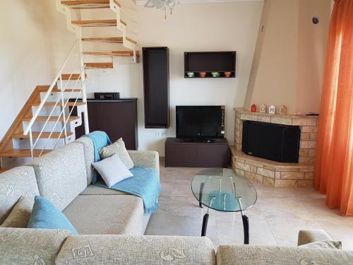 ein Wohnzimmer mit einem Sofa und einem Glastisch in der Unterkunft Villa Iris by RentalsPro - Agios Mamas Beach in Agios Mamas