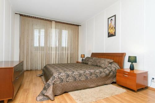 キーウにあるSribnokilska 22のベッドルーム(ベッド1台、ドレッサー、テレビ付)