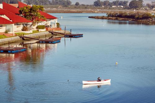 a small boat in the water next to a dock at First Group Port Owen Marina in Velddrif