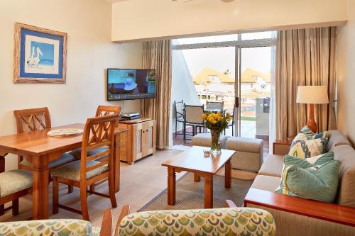 a living room with a couch and a table at First Group Port Owen Marina in Velddrif