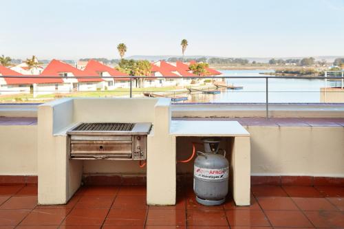 a grill on a balcony with a view of the water at First Group Port Owen Marina in Velddrif