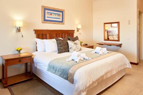 a bedroom with a bed with two stuffed animals on it at First Group Port Owen Marina in Velddrif
