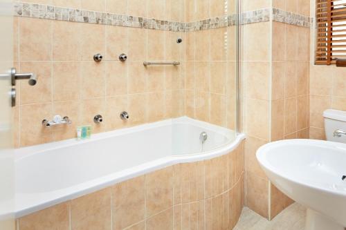 a bathroom with a bath tub and a sink at First Group Port Owen Marina in Velddrif