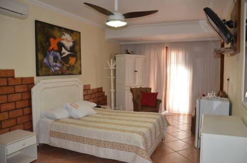 a bedroom with a bed and a ceiling fan at Telma Hotel in Bauru