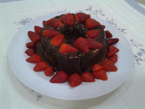 a chocolate cake with strawberries on a white plate at Telma Hotel in Bauru