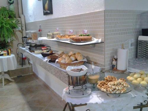 - un buffet avec du pain et d'autres aliments sur un comptoir dans l'établissement Telma Hotel, à Bauru