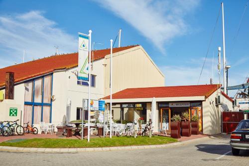 a building with tables and chairs in front of it at First Group Port Owen Marina in Velddrif