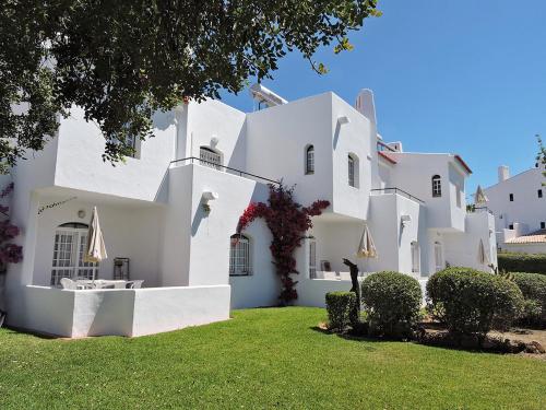 a large white house with a green yard at Verde Pino in Vilamoura
