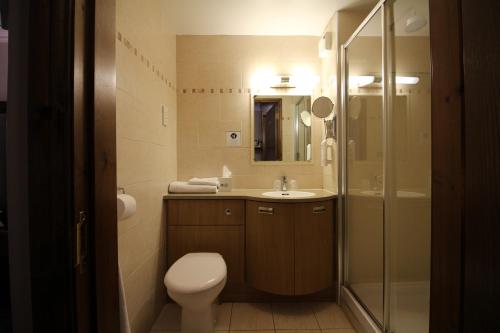 a bathroom with a toilet and a sink and a shower at Best Western Plus Pastures Hotel in Doncaster