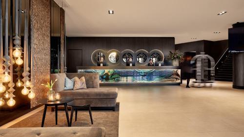 
a living room filled with furniture and a large window at Van der Valk Hotel Groningen-Hoogkerk in Groningen
